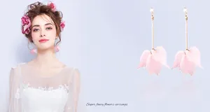 Macro detail of long tassel earrings with pink flower petals and sparkling crystals