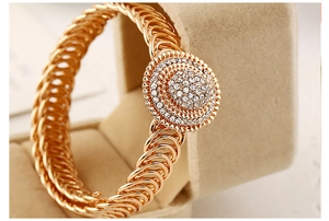 Macro-opname van goud vergulde schakelarmband met fonkelend diamanten middenstuk