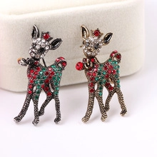 Close-up of vintage reindeer brooches with red and green rhinestones in gold and silver