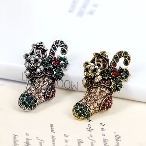 Macro detail of retro rhinestone Christmas stocking brooches in gold and silver plating