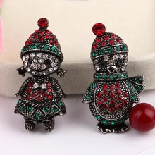 Close-up of Christmas brooches with girl and penguin designs featuring colorful rhinestones