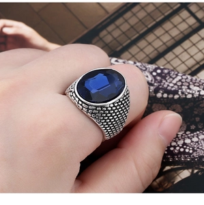 Detailed view of a men's vintage silver ring featuring a large faceted navy blue crystal