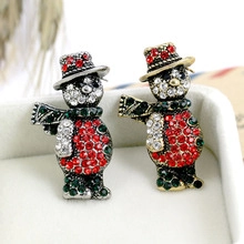 Macro shot of snowman Christmas tree brooches with red and white rhinestones and festive metal base