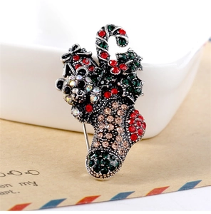 Detailed macro shot of a vintage Christmas bear and stocking brooch with colorful rhinestones