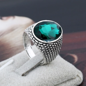 Men's vintage silver ring featuring a large oval emerald green crystal with textured band
