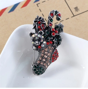 Macro shot of vintage silver Christmas brooch with colorful rhinestones on ceramic