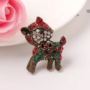 Vintage Weihnachts-Hirschbrosche mit bunten Strasssteinen und Goldfinish auf rosa Blumen