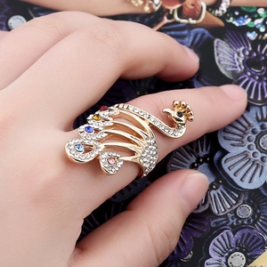Elegant peacock ring with colorful rhinestones and gold plating on a hand model