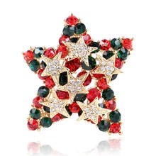 Détail de la broche étoile de Noël avec cristaux rouges et verts sur socle doré