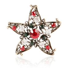 Gros plan d'une broche étoile vintage avec cristaux rouges, verts et clairs