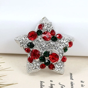 Détail de broche étoile de Noël vintage sertie de cristaux rouges, verts et blancs