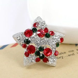 Détail de la broche étoile et lune avec strass rouges et verts sur enveloppe vintage