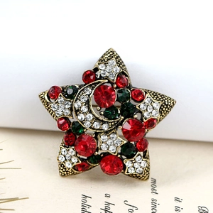 Gros plan d'une broche étoile de Noël vintage avec strass rouges, verts et blancs