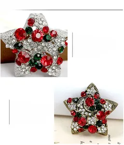 Détail d'une broche étoile de Noël vintage avec des strass rouges et verts