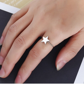 Gros plan d'une bague étoile argentée minimaliste montrant la finition en métal poli