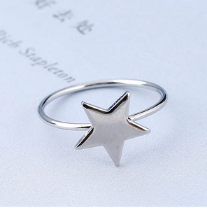 Vue macro d'une bague en métal argenté en forme d'étoile avec une finition polie lisse