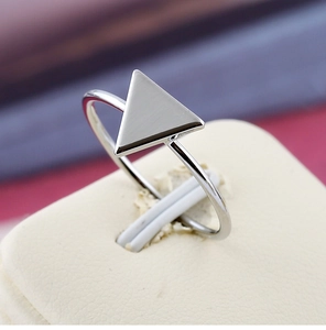 Vue macro d'une bague triangulaire argentée minimaliste sur un support en cuir