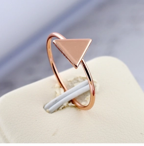 Vue macro de bague minimaliste en or rose avec détail géométrique triangulaire poli