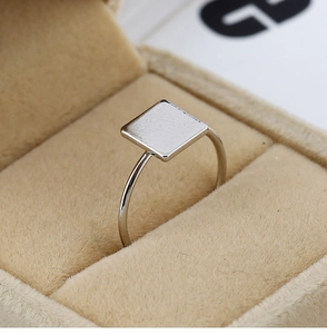 Bague carrée en métal argenté poli présentée dans un coffret à bijoux en velours