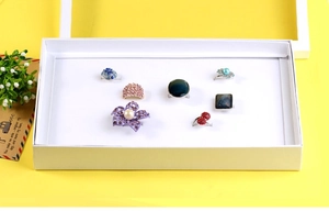Détail de 7 bagues de mode dans une boîte à 100 fentes incluant fleurs et styles cristal