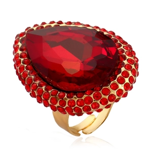 Macro shot of gold adjustable ring with a large pear-cut red crystal and pavé border