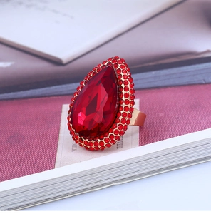 Close-up of a luxury pear-cut red crystal ring with gold-tone metal and pavé setting