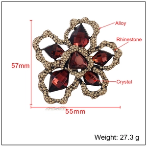 Vintage flower brooch featuring red crystals and small rhinestones on alloy frame