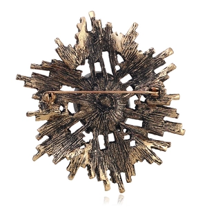 Vue arrière d'une broche vintage en bronze avec épingle de sûreté sur fond blanc