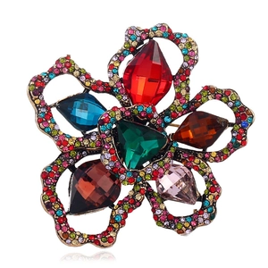 Detailed view of vintage flower brooch with multicolor gemstones and crystals on antique gold
