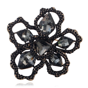 Macro detail of floral brooch featuring smoky grey faceted gems and black alloy petals
