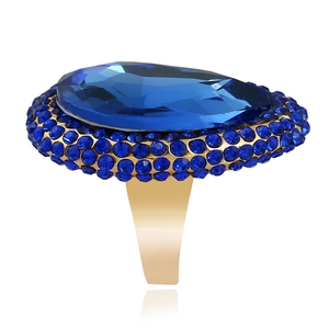 Chunky gold ring featuring a large teardrop blue crystal and pave side stones