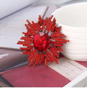 Détail de la broche étoile vintage dorée avec grand cristal rouge et strass micro-pave