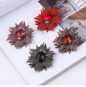 Broche étoile radiale avec strass étincelants et pierre centrale en quatre coloris
