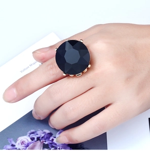 Detailed view of a gold multi-claw ring with a large faceted black gemstone on a model hand