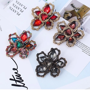 Vintage style floral brooches with large cut gemstones and intricate metal hollow petals