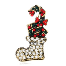 Dettaglio della spilla a forma di calza di Natale e bastoncino di zucchero con strass