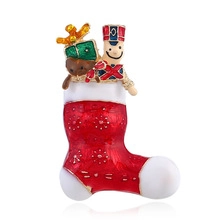Dettaglio della spilla a calza di Natale rossa con soldato schiaccianoci e regalo verde