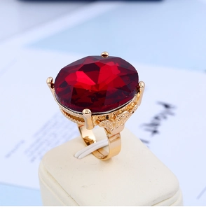 Macro detail of a large red crystal ring with gold filigree and adjustable band