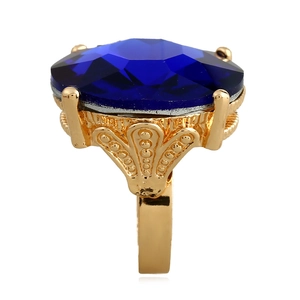 Vintage style gold ring featuring a large faceted blue gemstone with intricate filigree details
