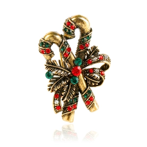 Detail of vintage Christmas candy cane brooch with red green crystals and bronze bow