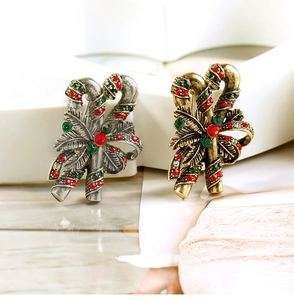 Detailed macro view of vintage Christmas candy cane brooches with rhinestones and bows