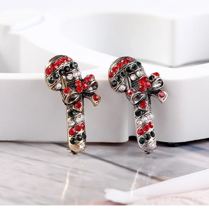Close-up of sparkling Christmas cane brooches with red and green rhinestones