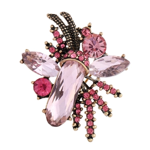 Macro shot of vintage bronze brooch with large teardrop pink gemstone and small rhinestones
