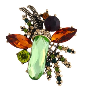 Macro detail of vintage insect brooch with colorful rhinestones on bronze metal base
