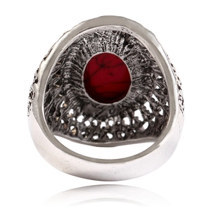 Vintage silver metal ring with oval red stone featuring textured relief details