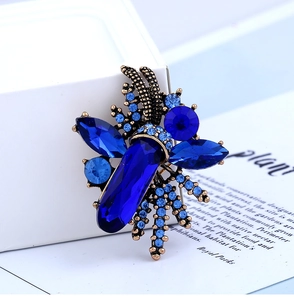 Close-up of vintage insect brooch with deep blue gemstones and an antique bronze finish