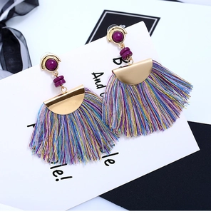 Detail of Bohemian fan-shaped tassel earrings with purple resin beads and gold accents