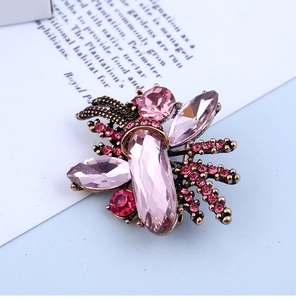 Close-up of vintage gold brooch featuring pink crystals and rose red rhinestones