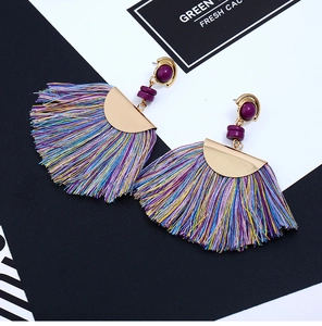 Detailed macro view of bohemian colorful tassel earrings with golden hardware accents