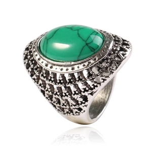 Close-up of vintage silver ring with oval green turquoise stone and intricate carvings